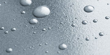 Detailfoto von abperlenden Wassertropfen auf einem Plakat